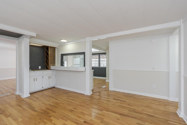 unfurnished living room featuring light hardwood / wood-style flooring and a textured ceiling