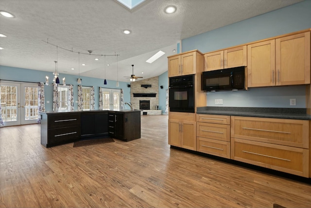 kitchen with decorative light fixtures, a textured ceiling, black appliances, and french doors