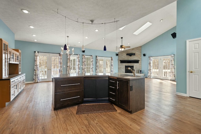 kitchen with sink, light hardwood / wood-style floors, and an island with sink