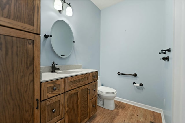 bathroom with hardwood / wood-style flooring, toilet, and vanity