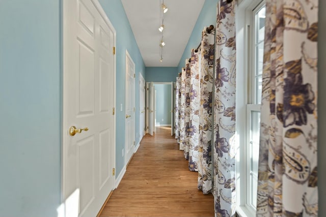 corridor featuring rail lighting and light wood-type flooring