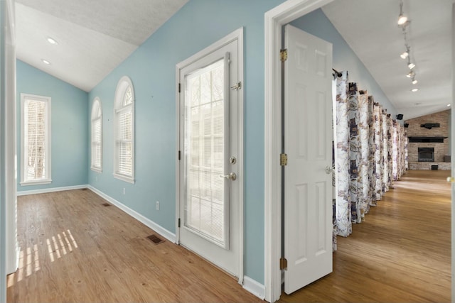 hallway featuring lofted ceiling and light wood-type flooring