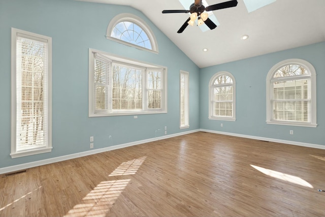 spare room featuring a wealth of natural light, light wood-type flooring, and vaulted ceiling