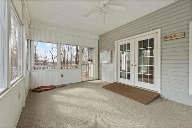 unfurnished sunroom featuring ceiling fan, a wealth of natural light, and french doors