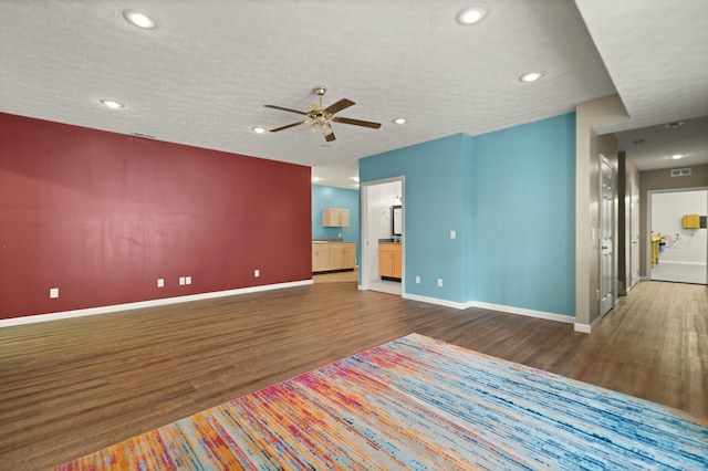 spare room featuring ceiling fan, dark wood-type flooring, and a textured ceiling