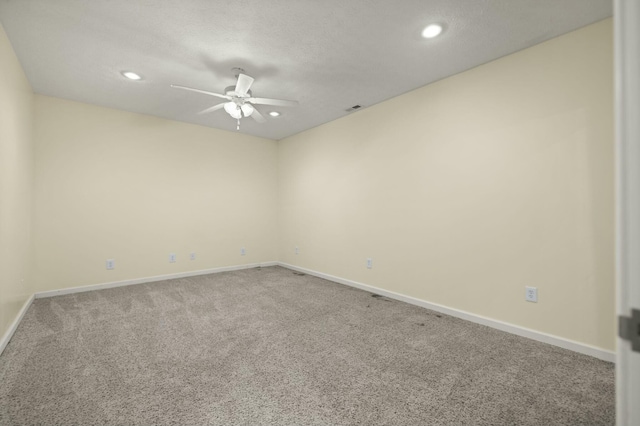 carpeted spare room with ceiling fan and a textured ceiling