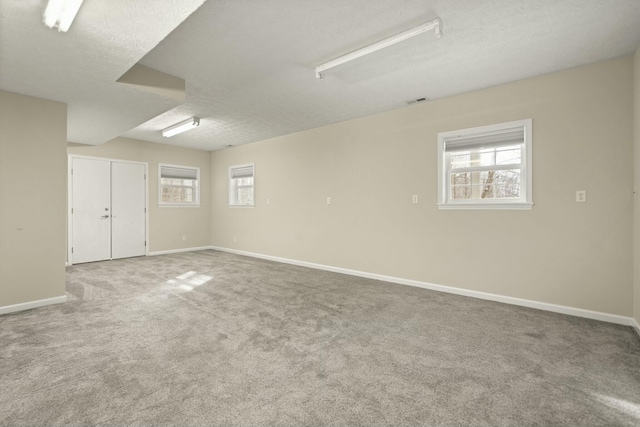 spare room featuring a textured ceiling and carpet floors