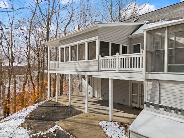 view of snow covered exterior with a sunroom