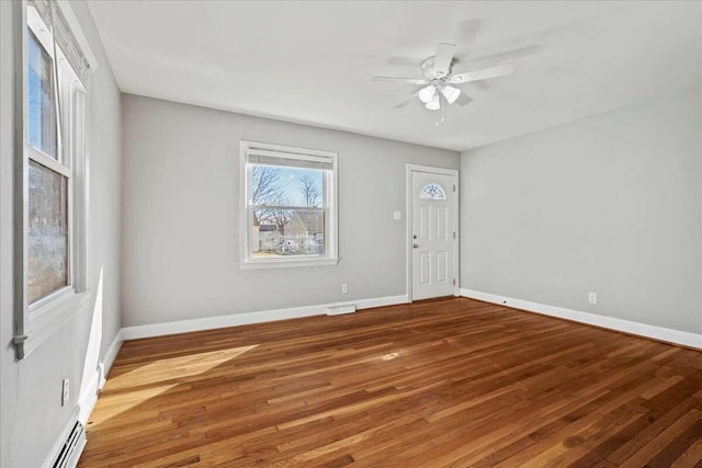 foyer entrance with hardwood / wood-style flooring, a baseboard radiator, and ceiling fan