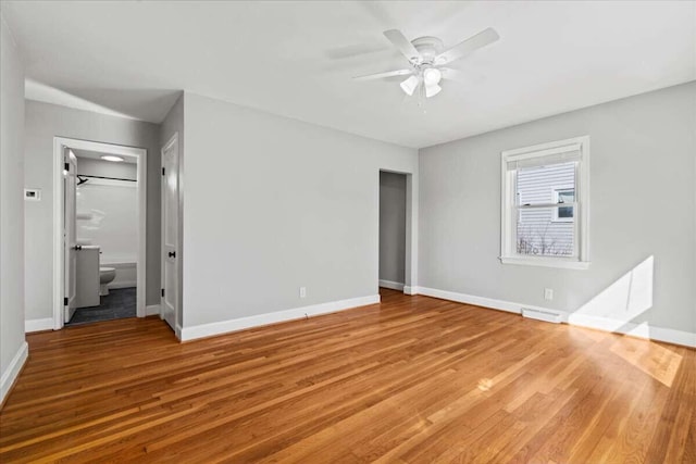 unfurnished bedroom with ensuite bathroom, hardwood / wood-style floors, and ceiling fan