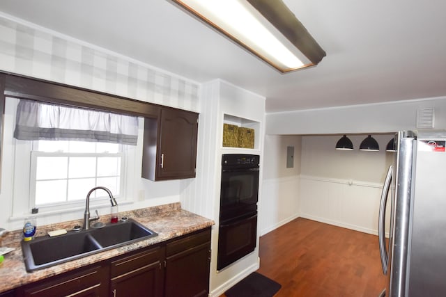 kitchen with double oven, dark brown cabinetry, stainless steel fridge, and sink