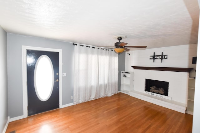 foyer entrance featuring ceiling fan, wood-type flooring, and a textured ceiling