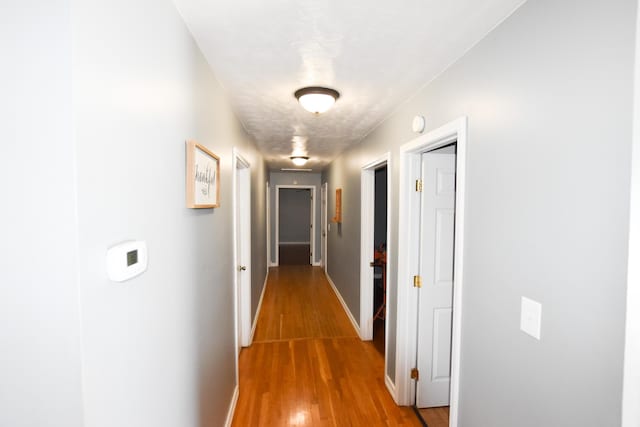 hall featuring wood-type flooring and a textured ceiling