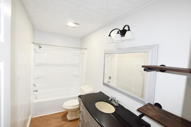 full bathroom featuring hardwood / wood-style flooring, shower / bathing tub combination, vanity, a textured ceiling, and toilet