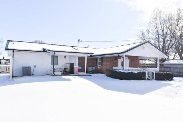 snow covered back of property featuring cooling unit