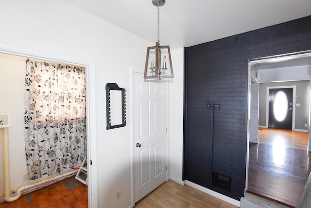 entrance foyer with wood-type flooring and a notable chandelier