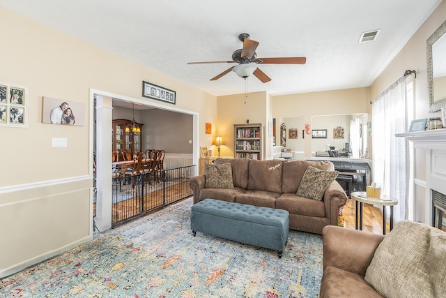 living room featuring ceiling fan and a textured ceiling