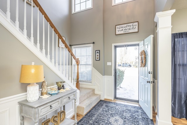 foyer entrance with light hardwood / wood-style flooring and ornate columns