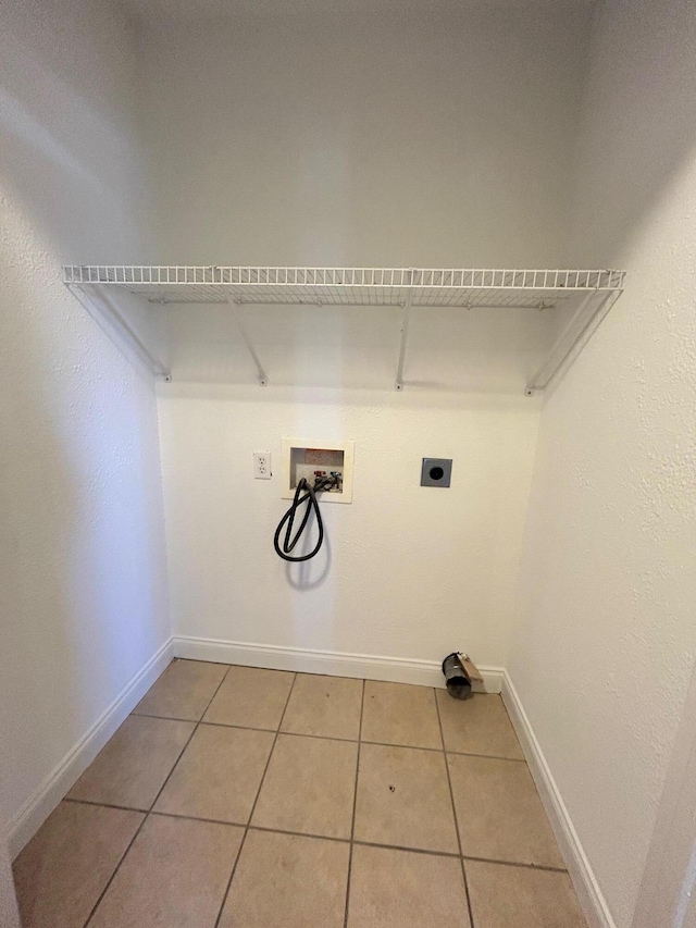 washroom with washer hookup, hookup for an electric dryer, and light tile patterned floors