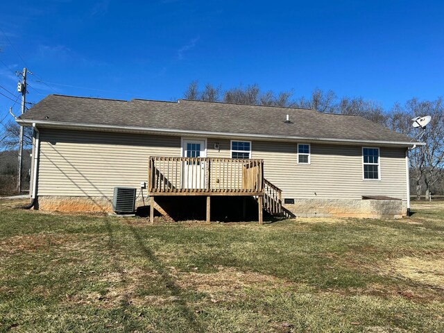 rear view of property with a wooden deck and a lawn