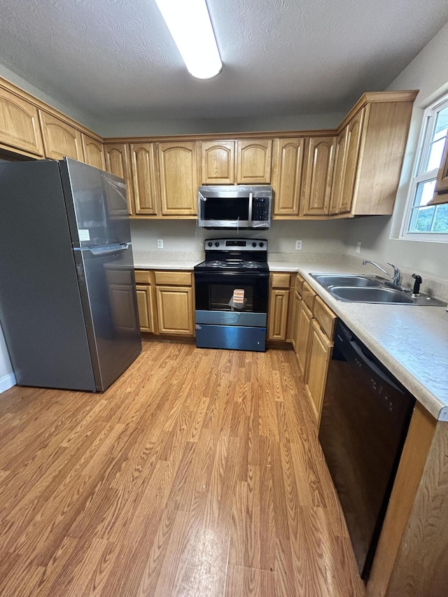 1465 Blaze Valley Rd, Somerset, KY 42501 - kitchen featuring appliances with stainless steel finishes, a sink, light wood-type flooring, light countertops, and a textured ceiling