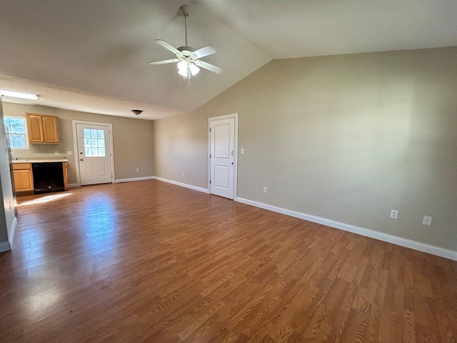 unfurnished living room featuring dark wood-type flooring, ceiling fan, and vaulted ceiling