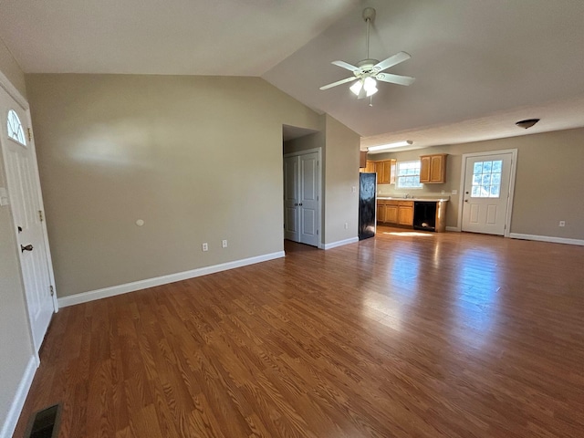 unfurnished living room featuring ceiling fan, vaulted ceiling, and dark hardwood / wood-style flooring