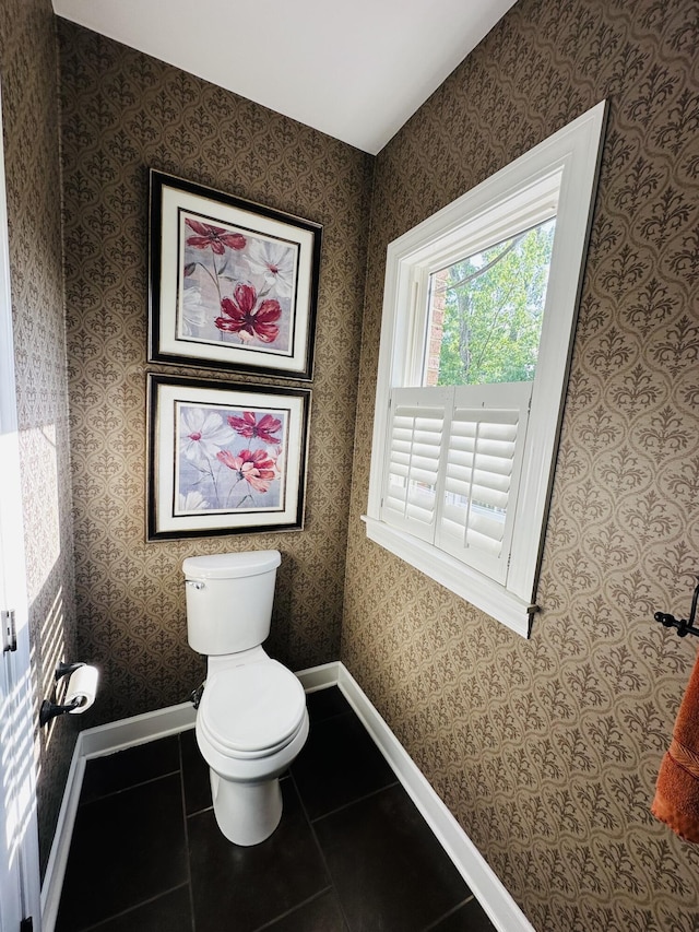 bathroom with toilet, tile patterned flooring, and baseboards