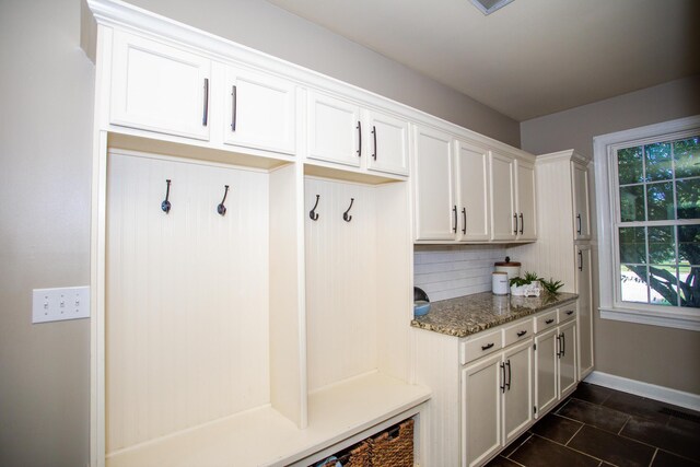 mudroom with dark tile patterned floors