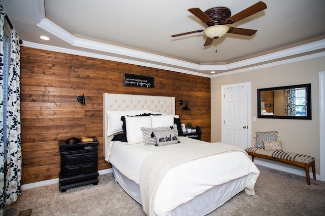 bedroom featuring light carpet, a tray ceiling, ornamental molding, and wooden walls