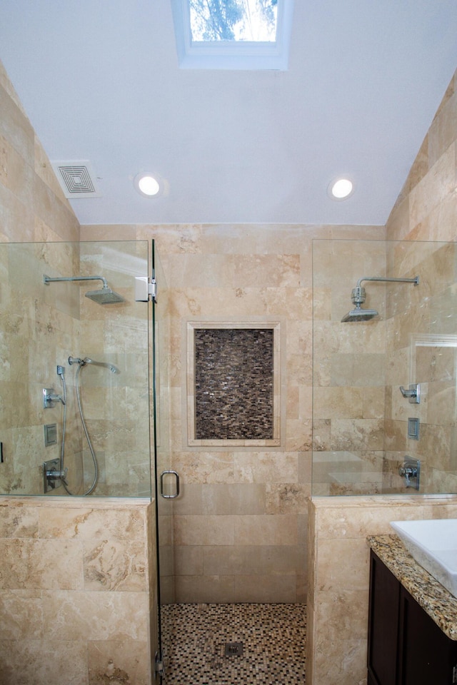 full bathroom featuring lofted ceiling, recessed lighting, vanity, visible vents, and a stall shower