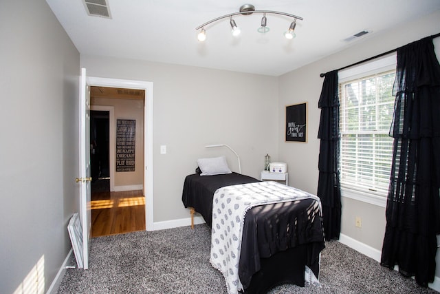 carpeted bedroom featuring visible vents and baseboards