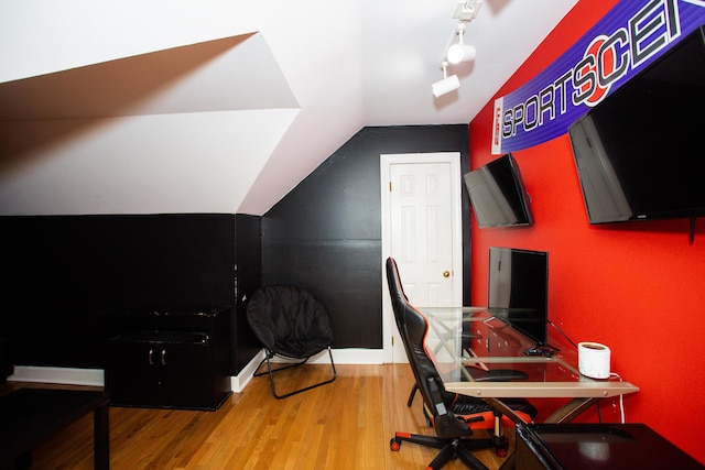 office space with lofted ceiling, wood finished floors, and track lighting