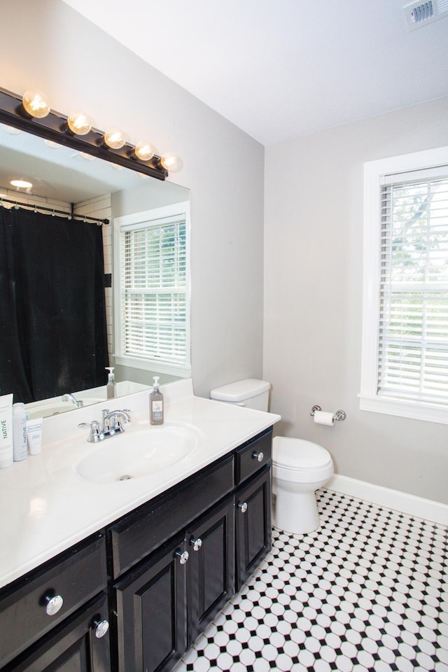 full bathroom with visible vents, baseboards, toilet, tile patterned floors, and vanity