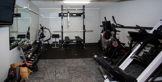 workout area featuring brick wall