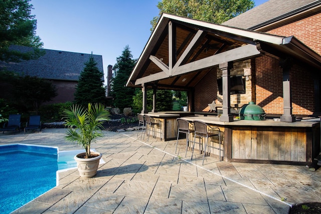 view of patio / terrace featuring outdoor dry bar and an outdoor pool