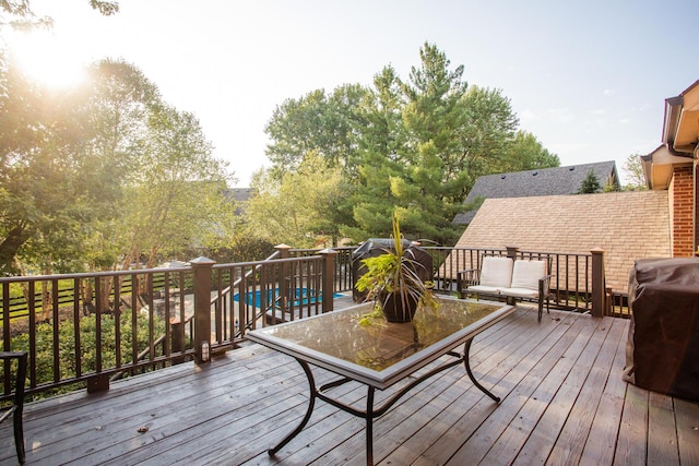 deck featuring outdoor dining space, grilling area, and an outdoor pool