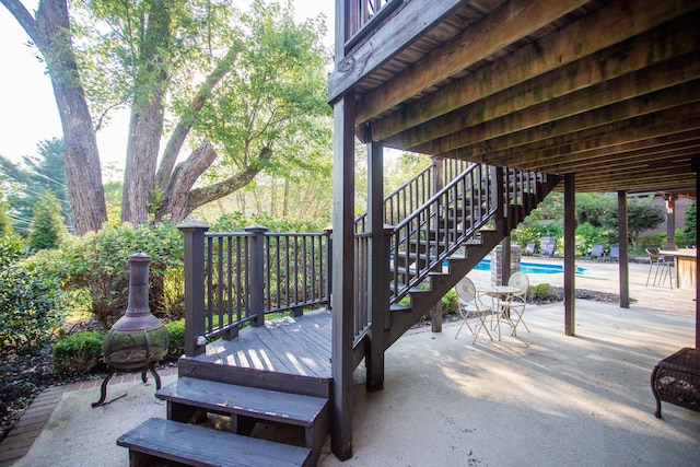 view of patio featuring a fenced in pool, stairway, and a deck