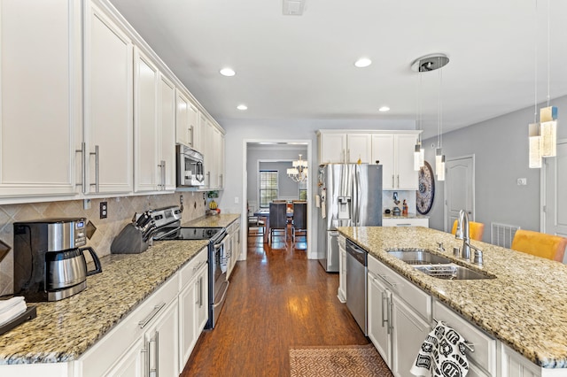 kitchen with stainless steel appliances, decorative light fixtures, sink, and white cabinets