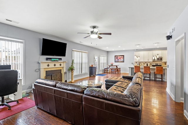 living room with ceiling fan and dark hardwood / wood-style flooring