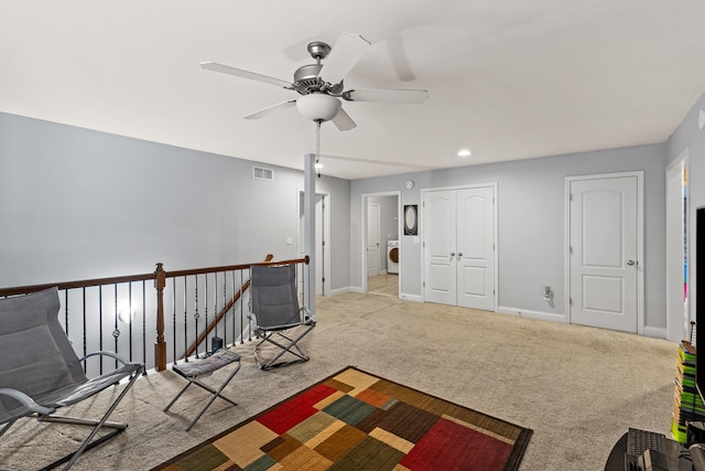 unfurnished room with ceiling fan, washer / clothes dryer, and light carpet