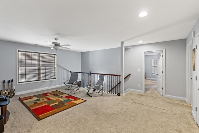 sitting room featuring light colored carpet and ceiling fan