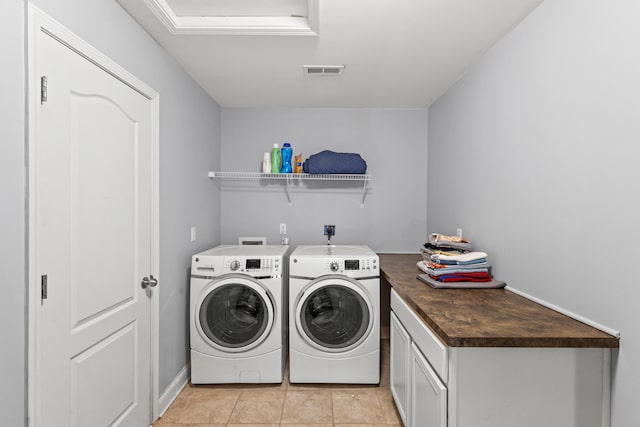 laundry area featuring light tile patterned floors and washer and clothes dryer