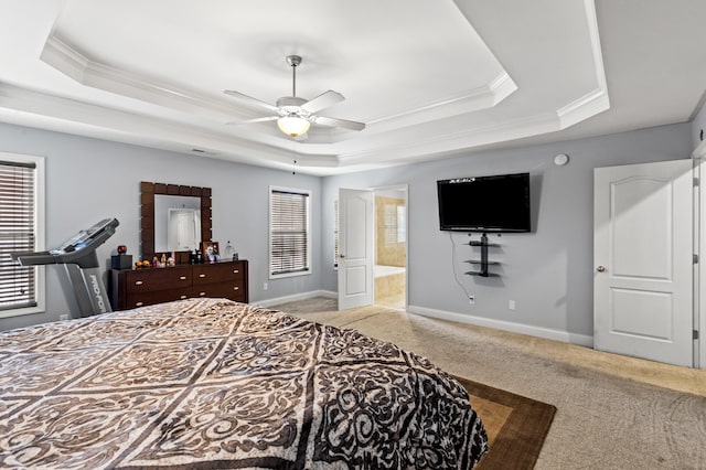 carpeted bedroom featuring a raised ceiling, ceiling fan, and ensuite bath