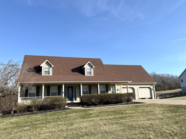 cape cod home with covered porch, concrete driveway, a front yard, and a garage