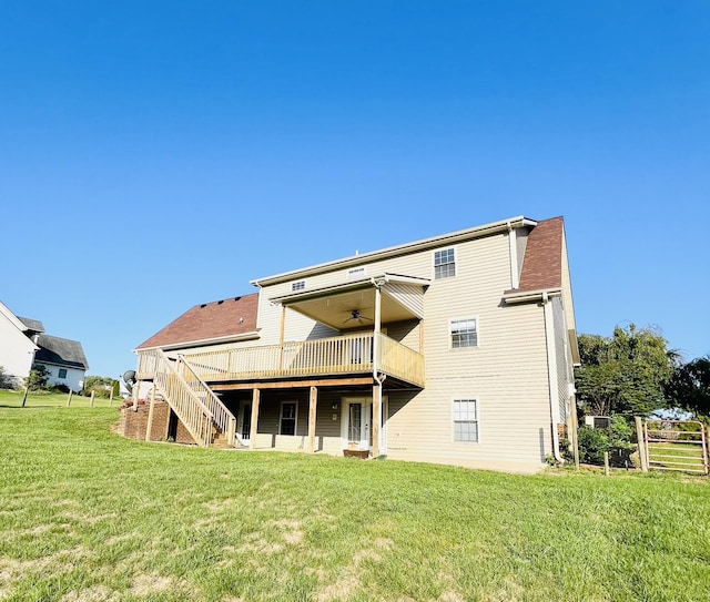 back of property featuring a ceiling fan, a yard, stairway, and a deck