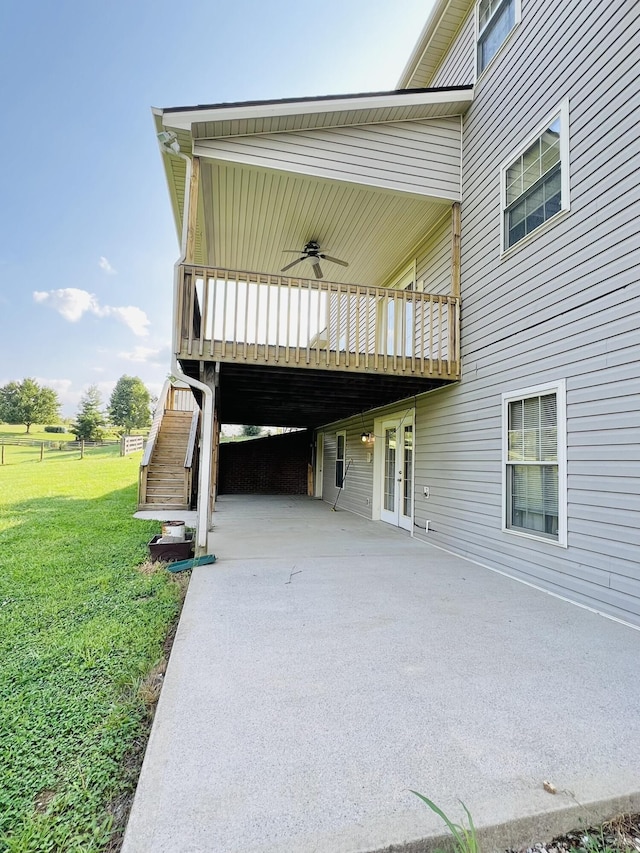 exterior space featuring a yard, ceiling fan, stairs, and french doors