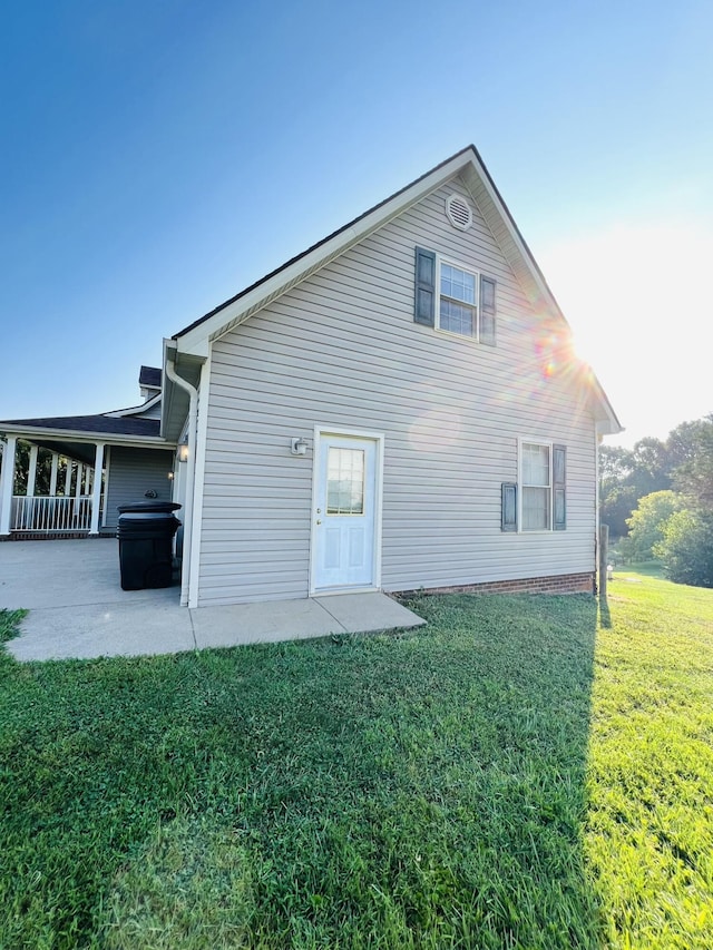 back of property with a patio area and a yard