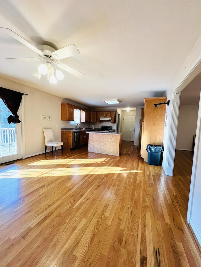 unfurnished living room featuring a ceiling fan, light wood-style flooring, and baseboards