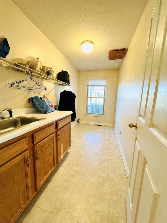 interior space featuring visible vents, a sink, and baseboards